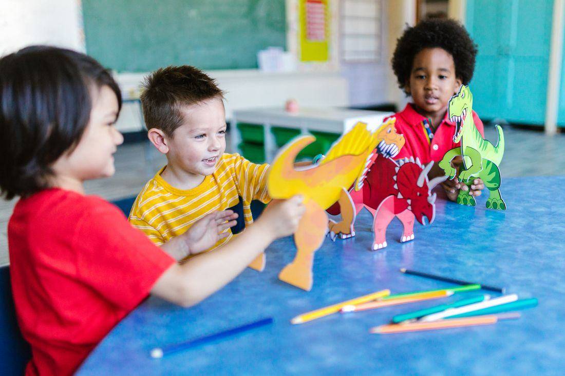 Children with dinosaur cut-outs