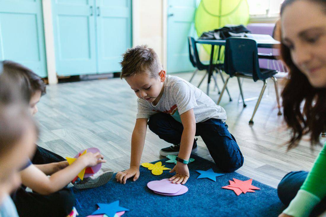 Children playing with shapes on the floor